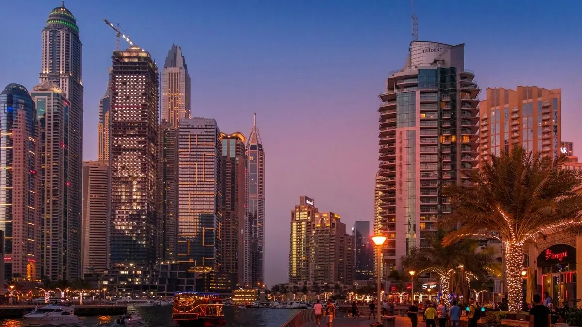 Alacakaranlıkta Dubai Marina: gökdelenler, yürüyüş yolu ve tekneler